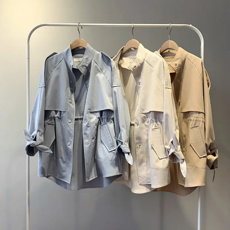 3 different colored jackets hanging for display with a grey background