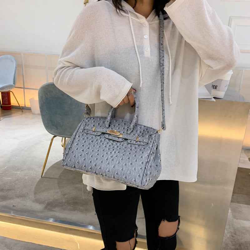 A lady carrying sa Ostrich pattern grey pu leather bag