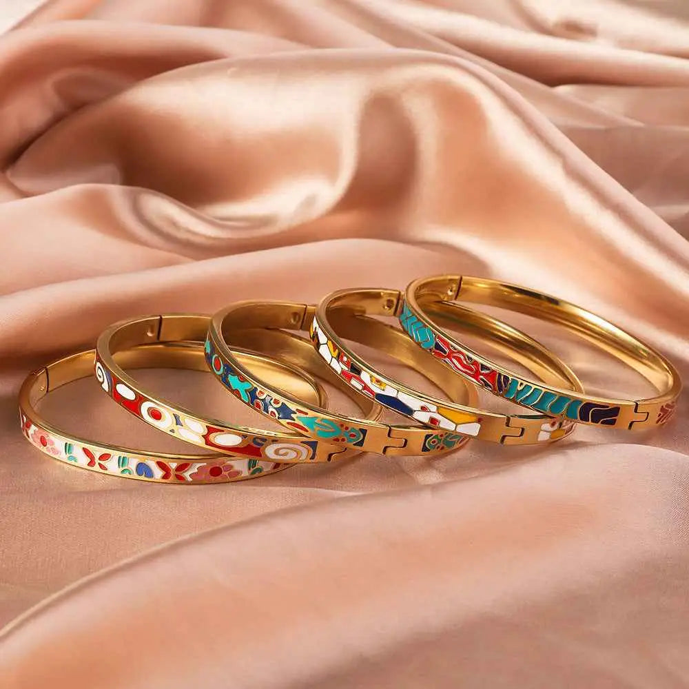 Coloured enamel gold bangles on a silk material