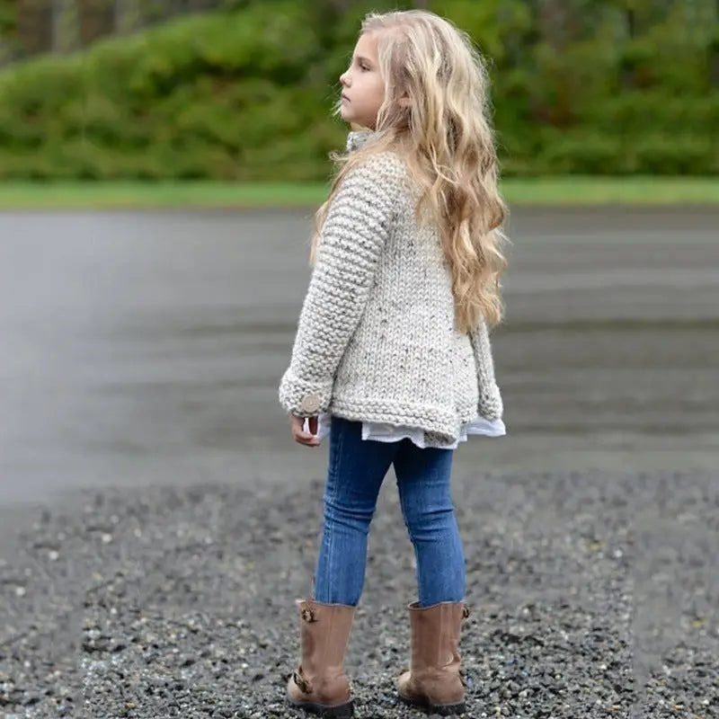 Girl wearing a beige cardigan with a outside background