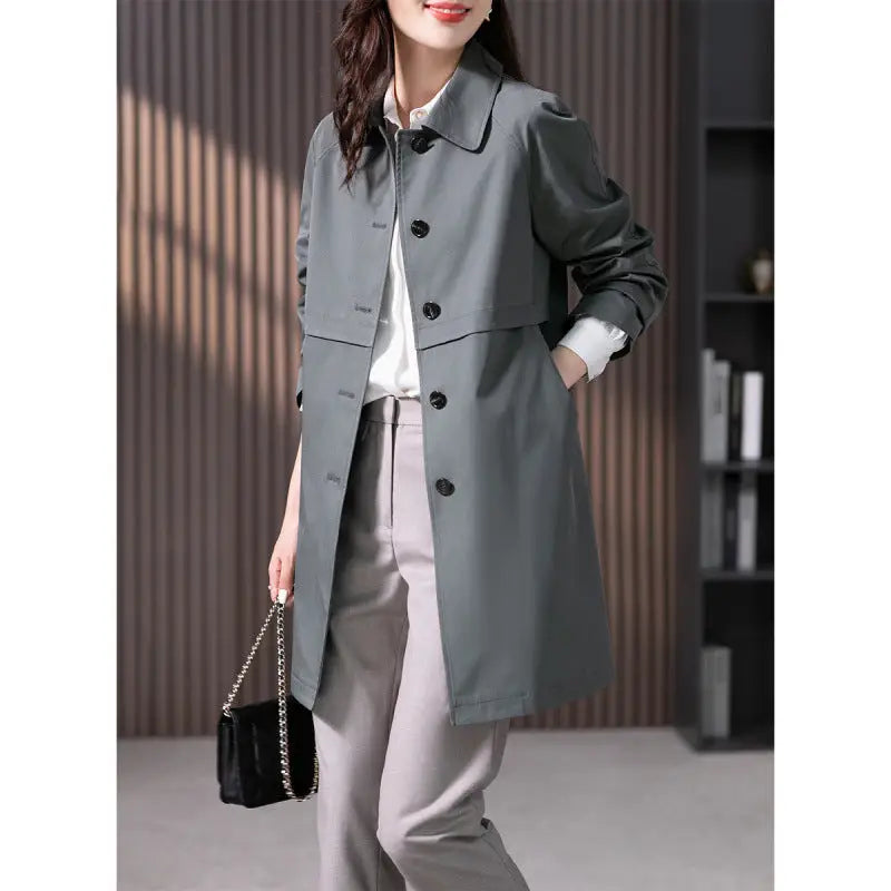 Woman wearing a grey coat with an office background