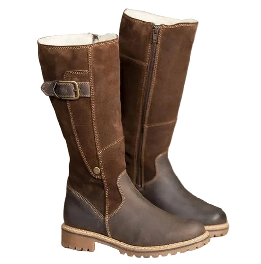 Pair of brown leather boots with fur lining on a wooden surface.