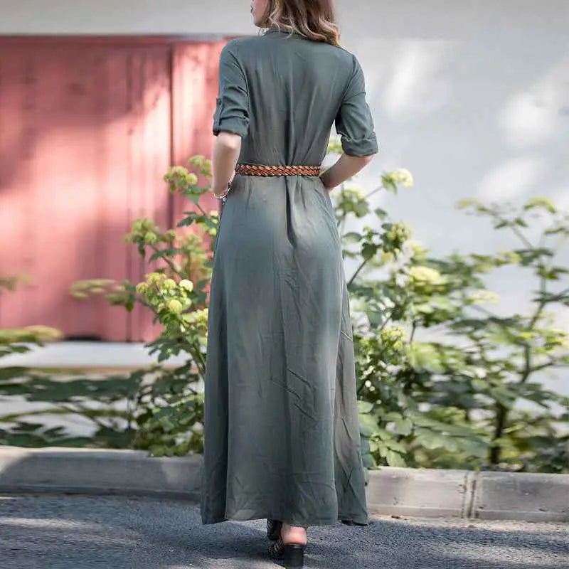 A woman wears an olive-green slim long dress in linen with shirt button front and braided brown belt detail