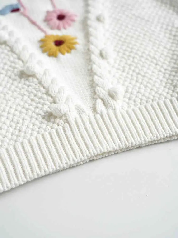 White knitted baby girls hand-embroidered floral cotton sweater with colorful flowers and textured cable knit details