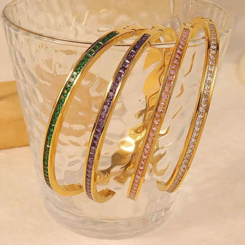 Four gold-toned crystal inlaid slim bangles with colorful rhinestones on stainless steel 2mm bands in linear pattern