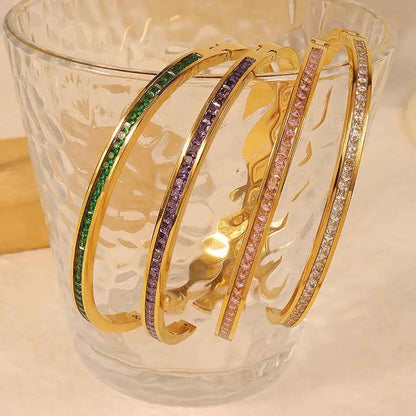 Four gold-toned crystal inlaid slim bangles with colorful rhinestones on stainless steel 2mm bands in linear pattern