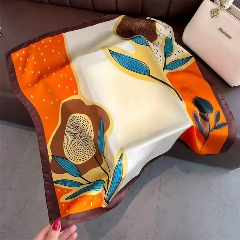 A vibrant dopamine-print silk feel square scarf in orange cream and brown with teal botanical leaves from trend den Sunflower Orange