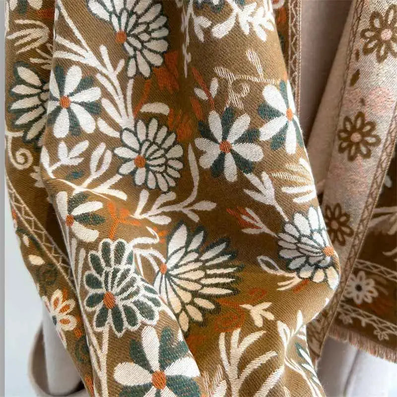 A soft earth-toned floral cashmere-feel warm shawl with white and green daisies and orange centers from trend den