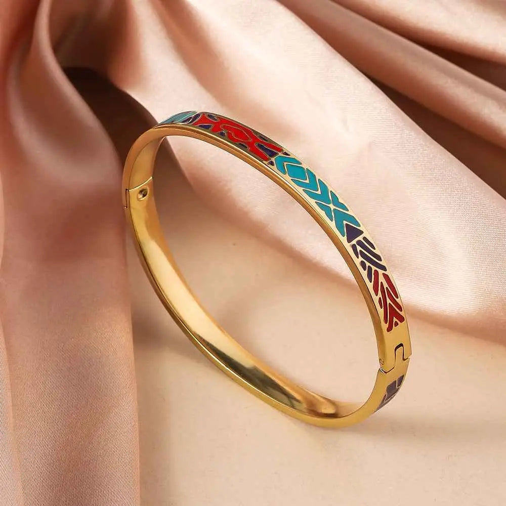 Gold bangle bracelet with intricate floral enamel gold inlays in red blue and black titanium steel design
