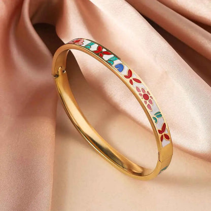 Floral enamel gold bangle bracelet in titanium steel with red green and blue flowers on a gold tone background Red And White Powder