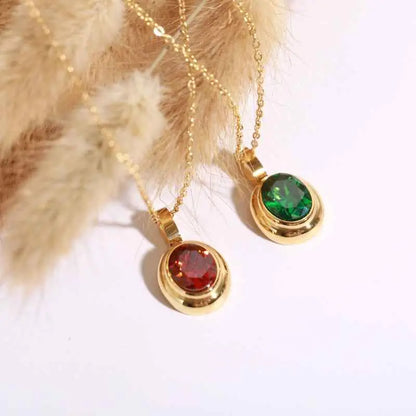 Two 18k gold gemstone necklaces from trend den featuring red and green round-cut stones in polished bezels