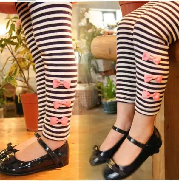 Girls bow accent tunic and black and white striped leggings set featuring pink bow embellishments for trend den style
