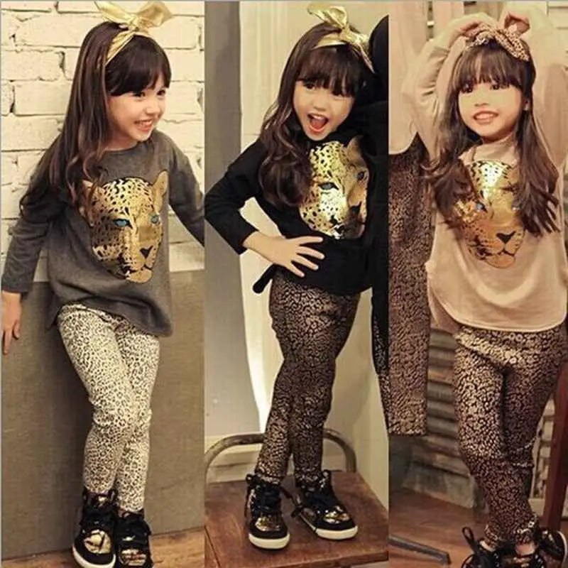 Girls leopard print three-piece outfit with gold embossed cheetah top, patterned leggings, and black metallic sneakers