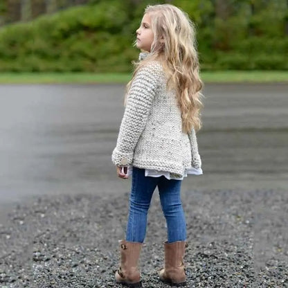 A child wearing a light gray girls rabbit hair blend knit cardigan with subtle speckled texture paired with blue jeans and brown boots