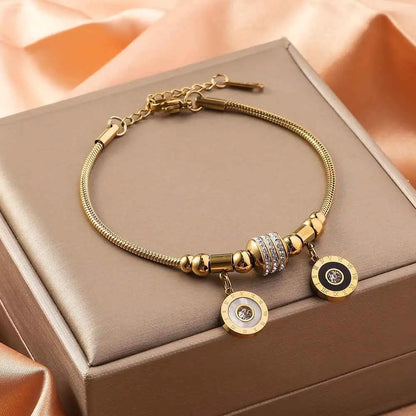 Gold shell charm bracelet in gold-toned titanium steel with crystal bead, polished beads, and roman numeral charm Double Circle