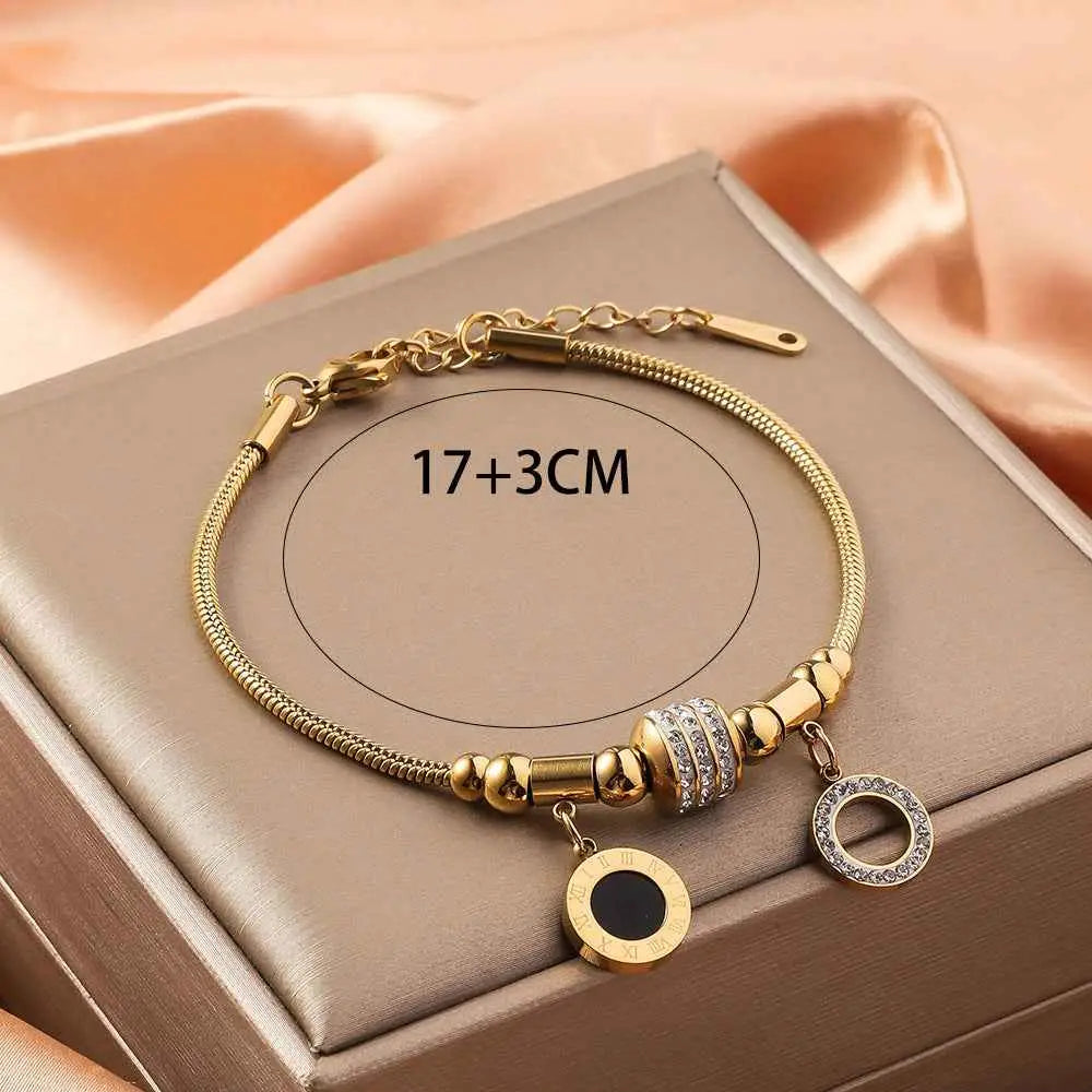 Gold shell charm adjustable charm bracelet in gold-toned titanium steel with crystal encrusted charms and polished beads