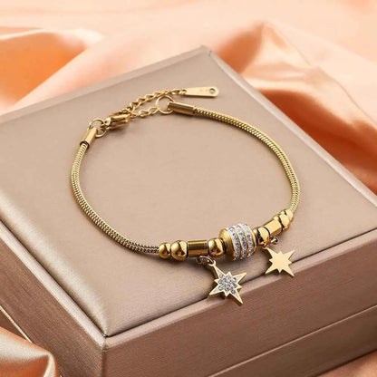 Gold shell charm bracelet in gold-toned titanium steel with a crystal-encrusted bead and two star charms dangling SIX STAR Awn