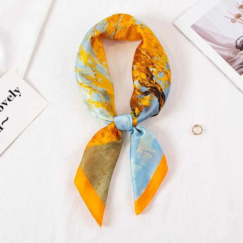 High-end 90cm floral silk feel scarf in vibrant yellow and blue abstract pattern with orange-trimmed ends tied in a knot