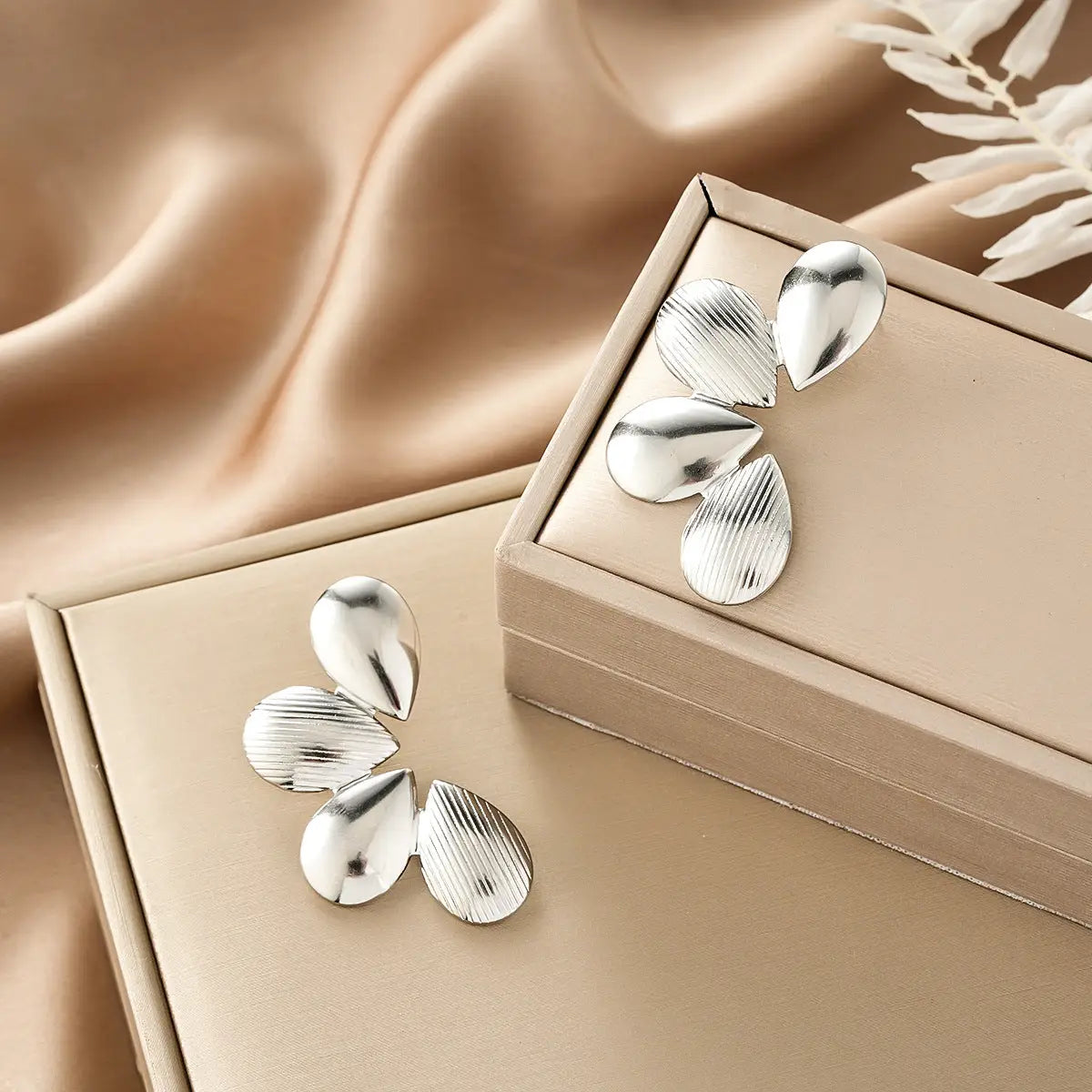 Silver teardrop earrings with brushed finish and vertical grooves in beige boxes from ins style gold fashion earring collection affordable luxury Style 27