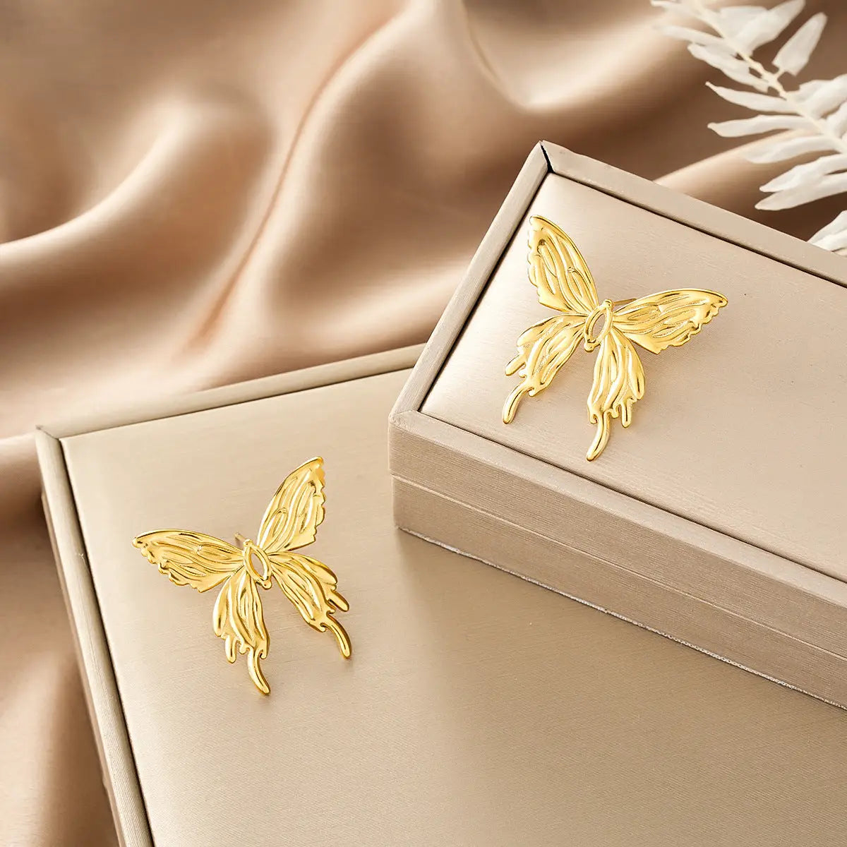 Gold butterfly-shaped pin with intricate wing detailing from ins style gold fashion earring collection on beige gift box Style 39