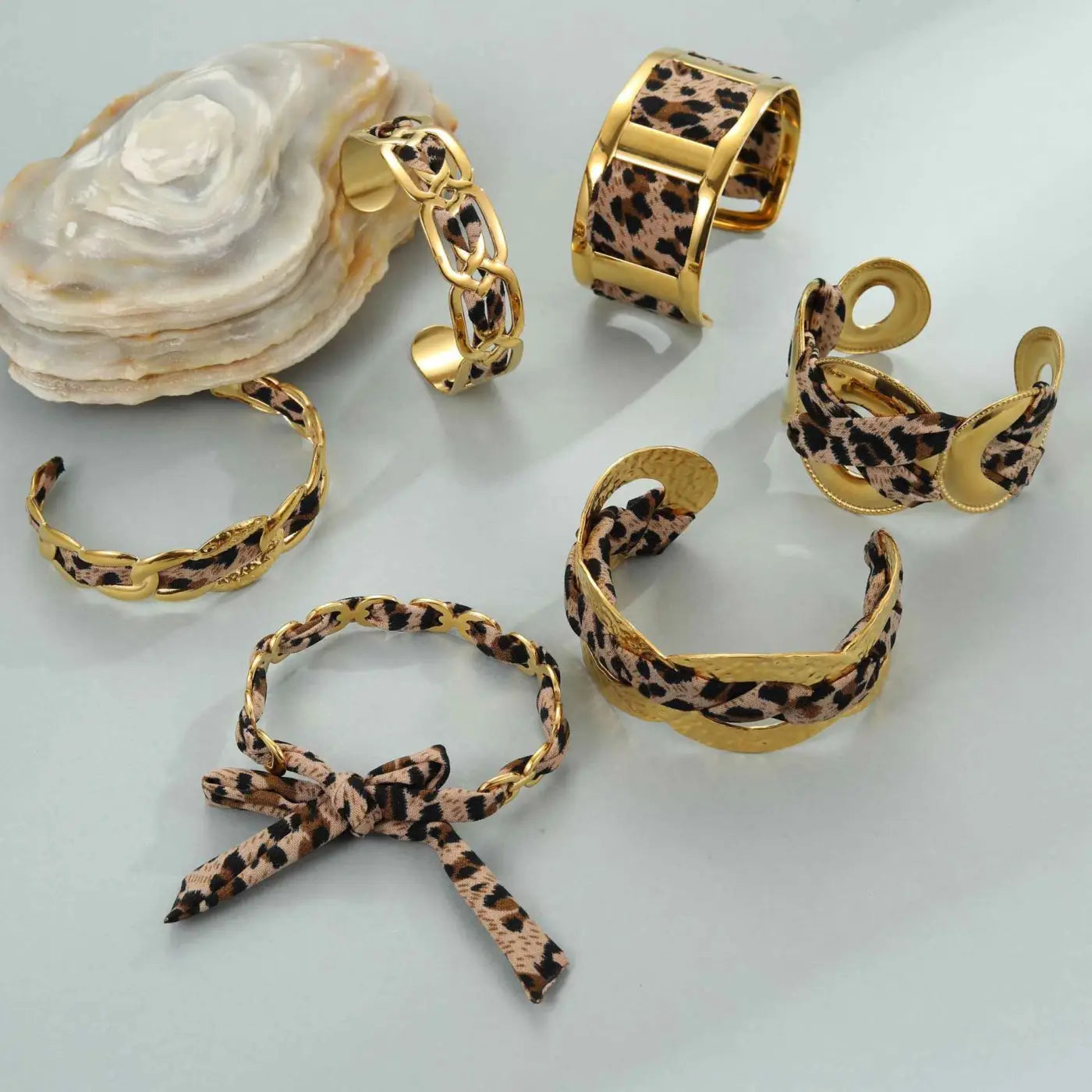 Gold-toned leopard ribbon geometric cuff bracelets with sleek modern design and leopard print pattern