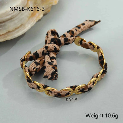 Gold-toned chain bracelet with leopard ribbon fabric bow in a leopard ribbon geometric bangle design NMSBK6163
