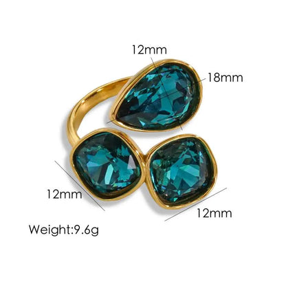 Gold-toned stainless steel zircon ring with three faceted teal gemstones in pear and square cut by trend den Peacock Blue