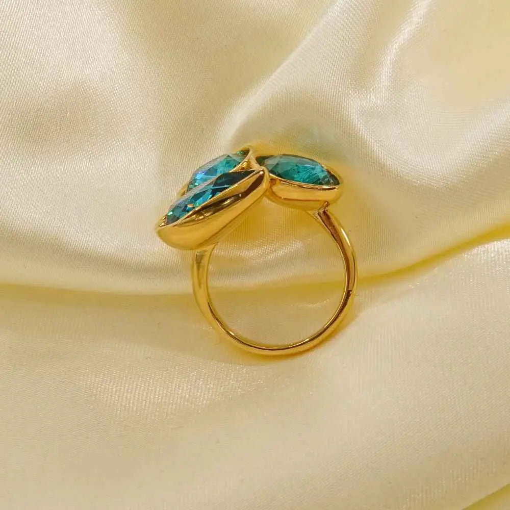 Gold zircon ring with two teal marquise-cut stones in a sleek modern stainless steel design from trend den