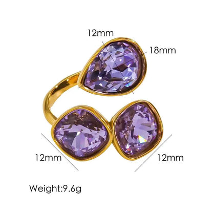 Gold-toned stainless steel zircon ring with three faceted purple crystals in teardrop and square shapes from trend den Violet