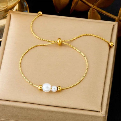 Gold-toned adjustable titanium steel bracelet with braided chain, white pearls, and gold beads in fashion bracelet collection 5222 Pull Double White Pearl