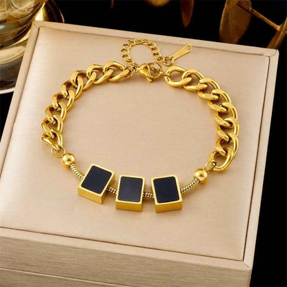 Gold chain bracelet with black square charms on a beige box 5263 Three Black Squares