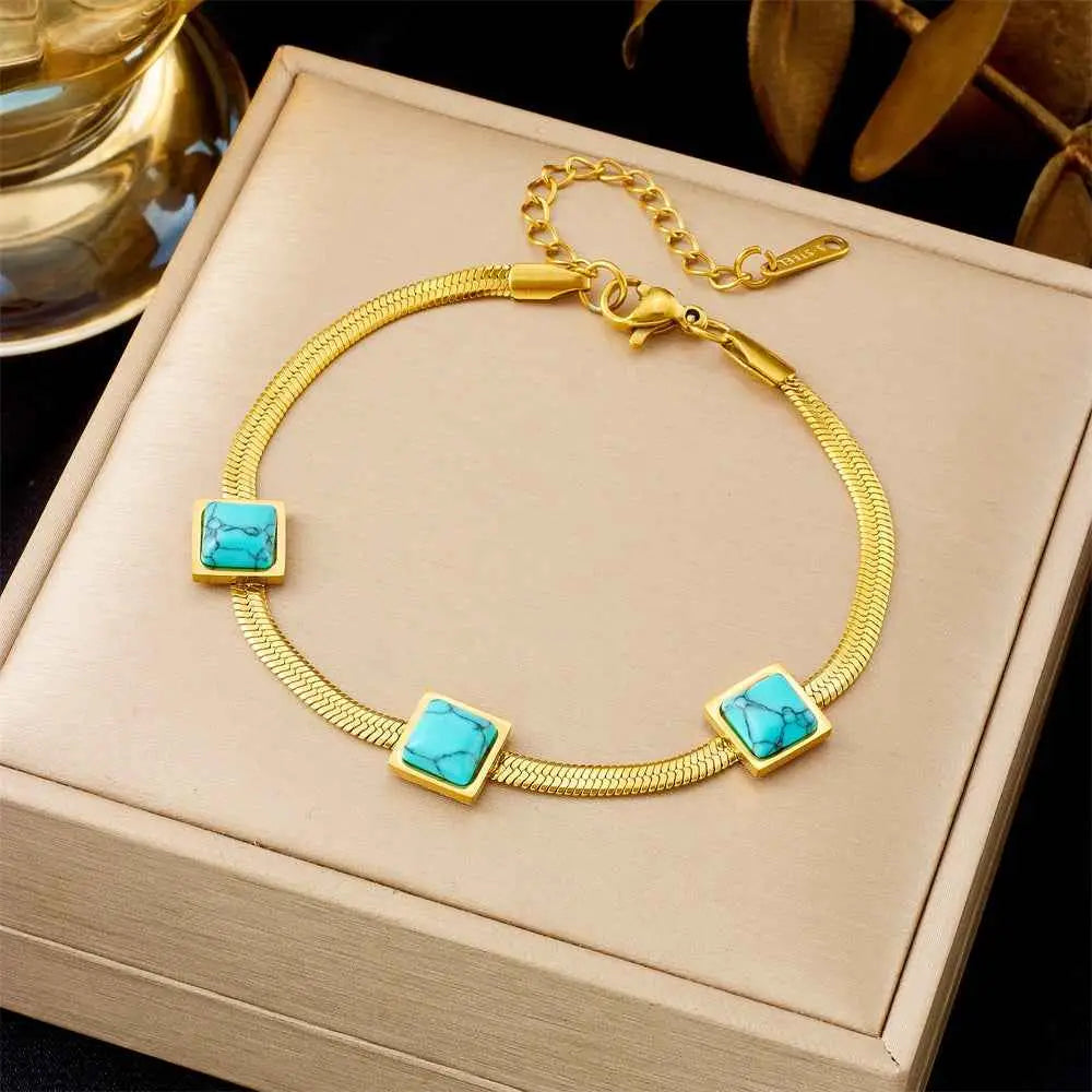 Gold bracelet with turquoise stones on a beige jewelry box 5292 Three Malachite
