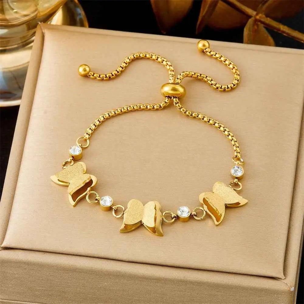 Gold bracelet with butterfly charms on a beige box 5307 Pull Three Butterflies