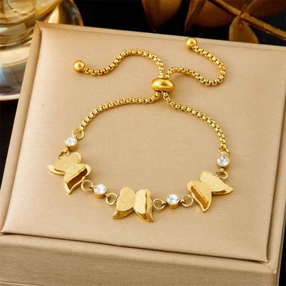 Gold bracelet with butterfly charms on a beige box 5307 Pull Three Butterflies