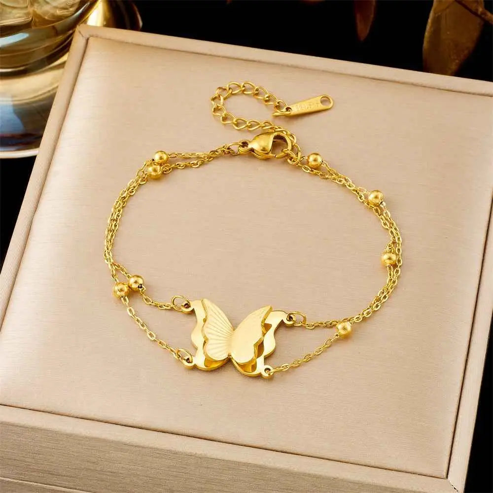Gold bracelet with butterfly charms on a beige jewelry box 5313 Bead Necklace Butterfly