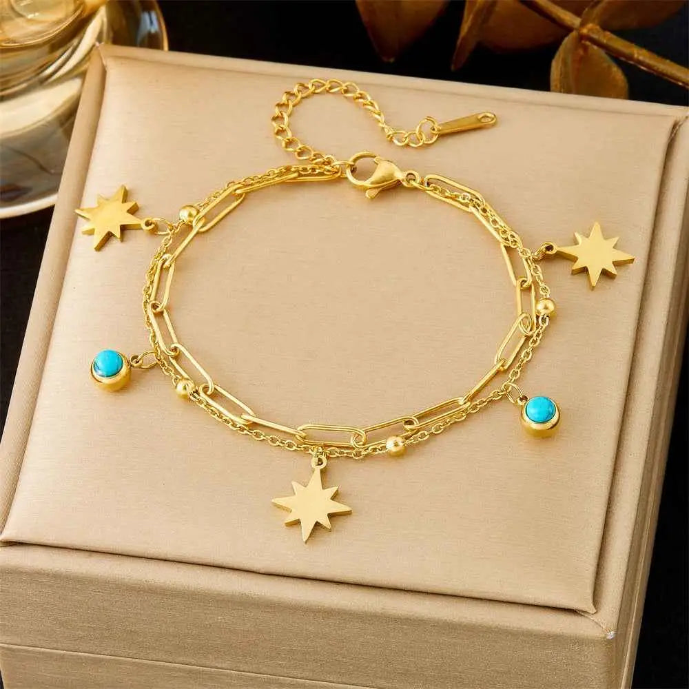 Trend Dens Gold bracelet with star and turquoise charm on a beige jewelry box 5317 SUNFLOWER