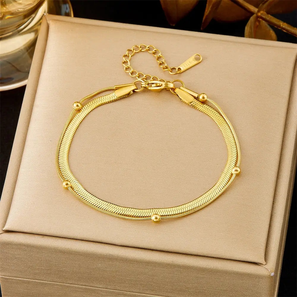 Gold bracelet on a beige jewelry box with a dark background 5354 Round Beads Blade