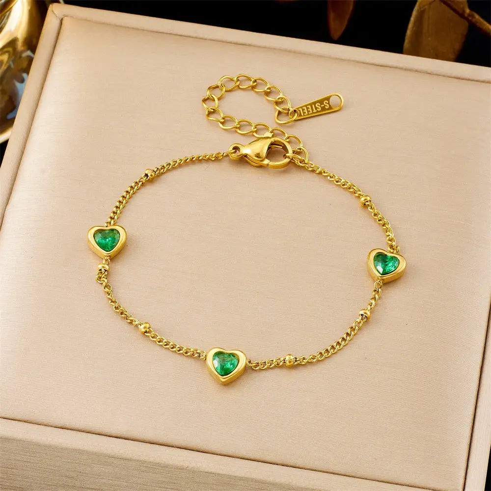 Trend Dens Gold bracelet with heart-shaped green gemstones on a beige box 5388 Green Three Hearts