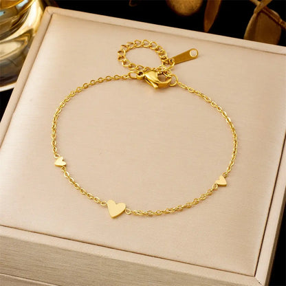 Trend Dens Gold bracelet with heart charms on a beige jewelry box 551 Three Hearts