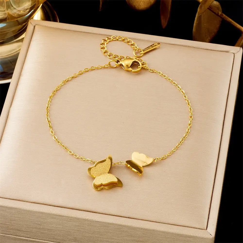 Gold bracelet with butterfly charms on a beige box 552 Frosted Butterfly
