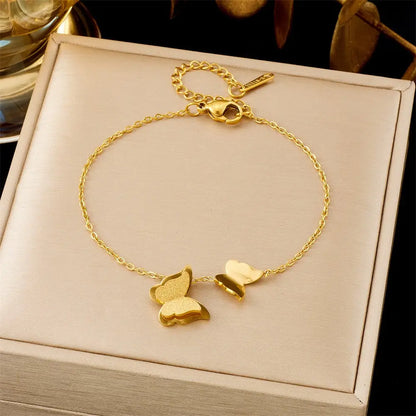 Gold bracelet with butterfly charms on a beige box 552 Frosted Butterfly