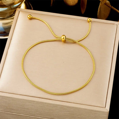 Adjustable Gold bracelet on a beige jewelry box with a dark background 567 Pull