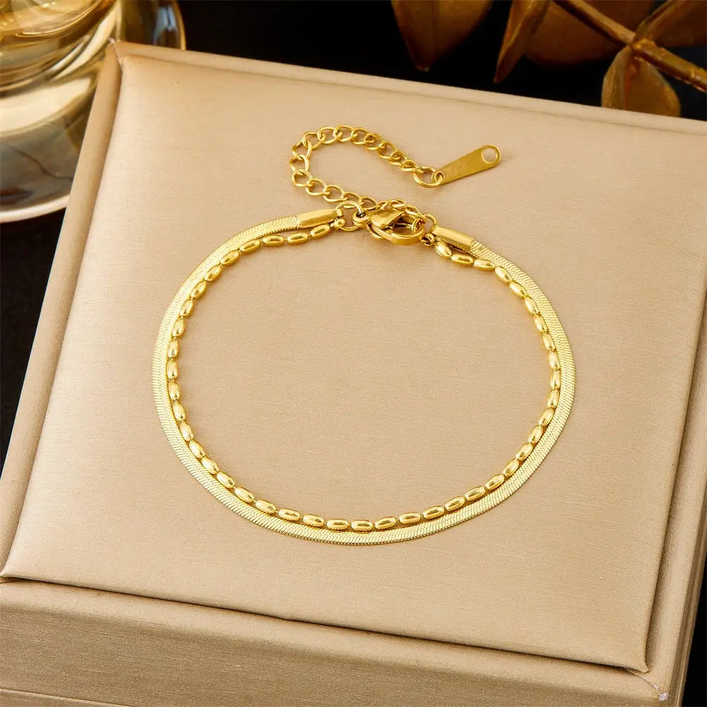 Layerded Gold bracelet on a beige jewelry box with a dark background 578 Bead Blade