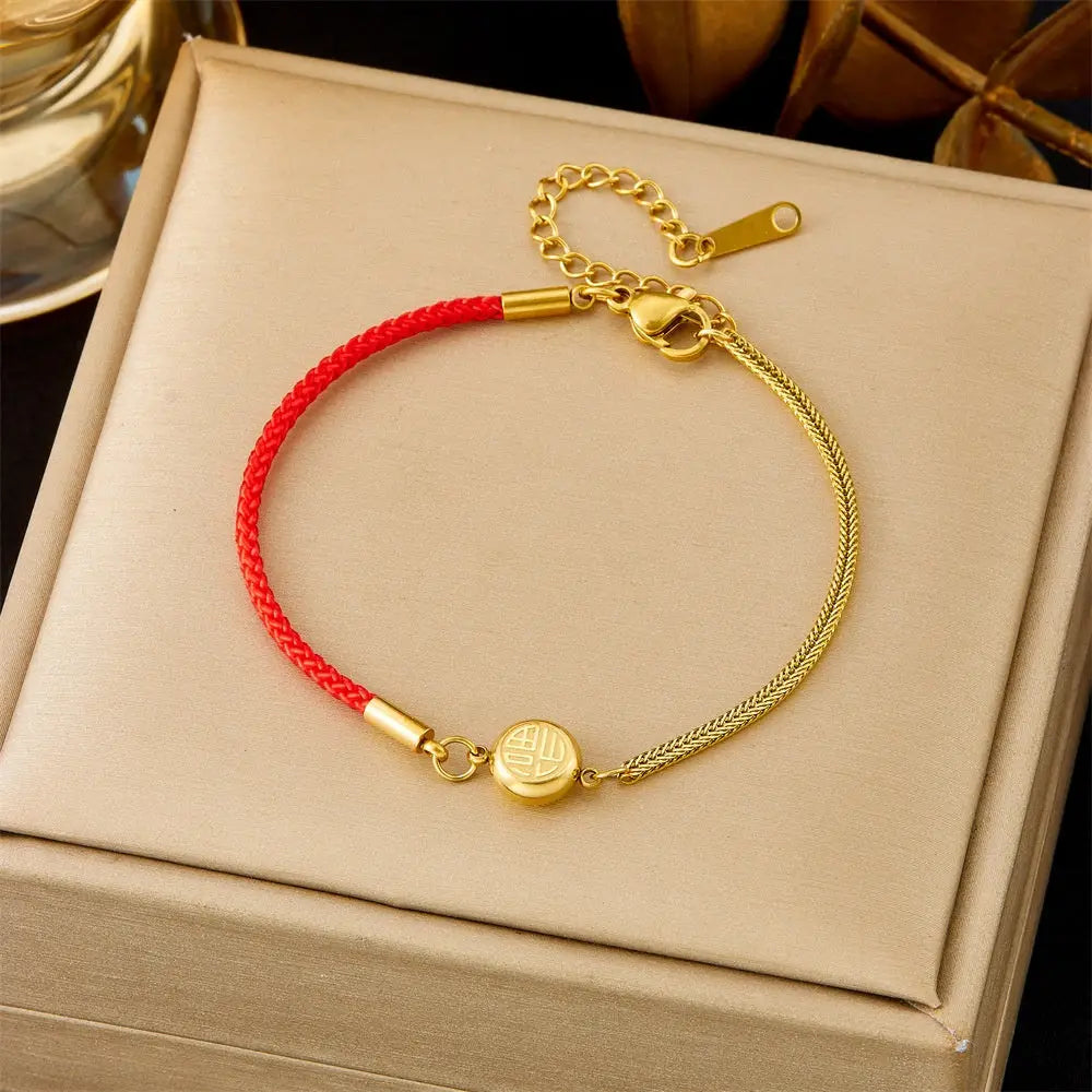 Trend Dens Gold bracelet with a red cord on a beige box 596 Red Rope Blessing
