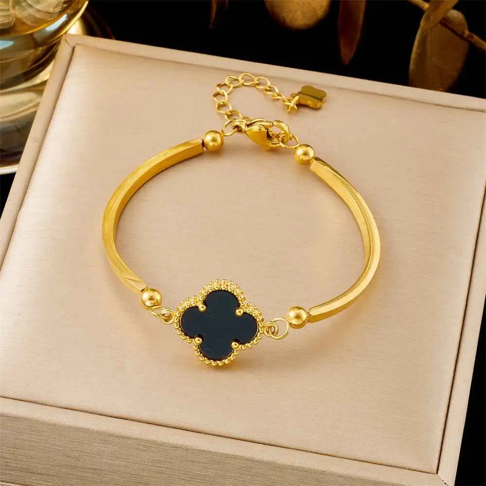 Gold-toned titanium steel fashion bracelet with dark blue enamel clover pendant and beaded accents from trend den collection