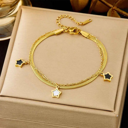 Gold-toned titanium steel snake chain fashion bracelet with three star-shaped charms in black and white from trend den collection