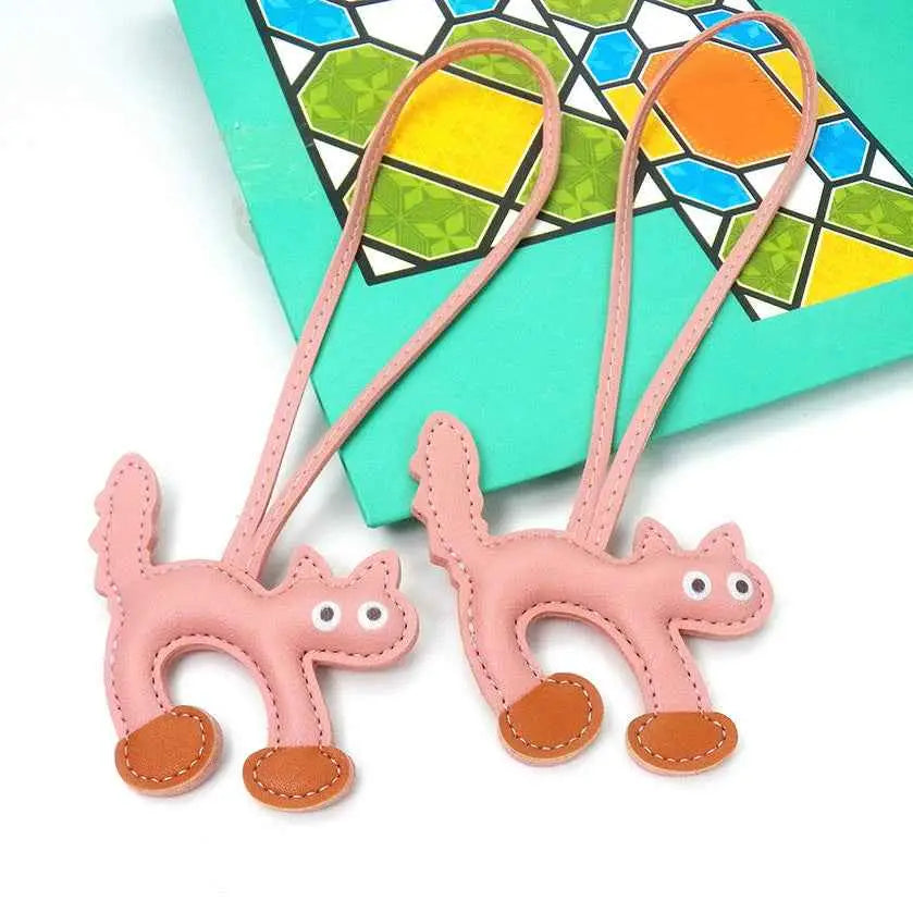 Pink leather mini cat bag charm with brown stitched feet and white button eyes from trend den cat bag collection Pink