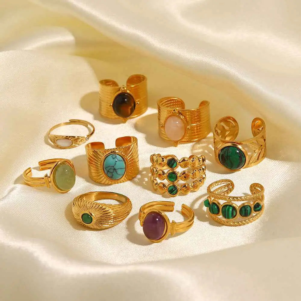 A collection of gold-toned natural stone adjustable zircon rings featuring turquoise malachite and amethyst gemstones