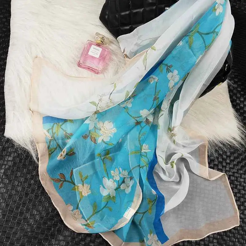A delicate blue and white oil painting floral silk sunscreen scarf with beige border and elegant blossoms on sheer fabric A