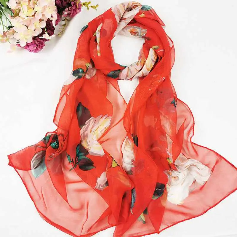 A vibrant red sheer georgette scarf with oil painting floral pattern in soft white and green hues for sunscreen use A